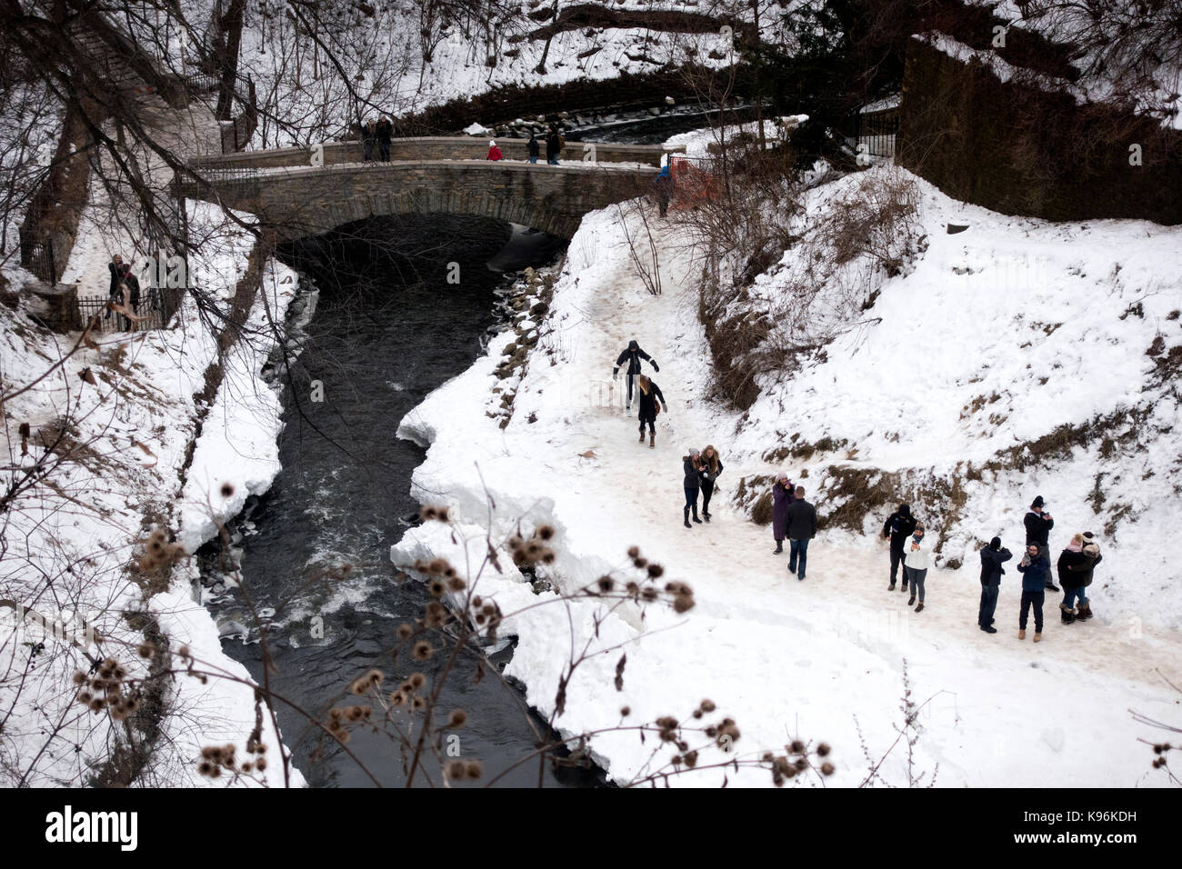 People walking along the riverbank of Minnehaha creek on its way to the Mississippi river St Paul Minnesota MN USA Stock Photo