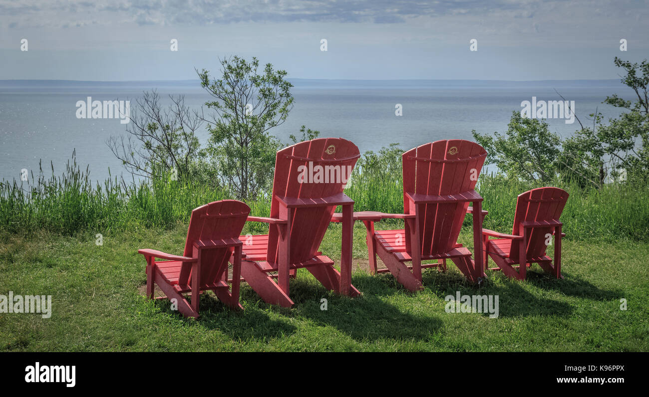 Brightly-colored outdoor lounge chairs facing calm waters of the Bay of