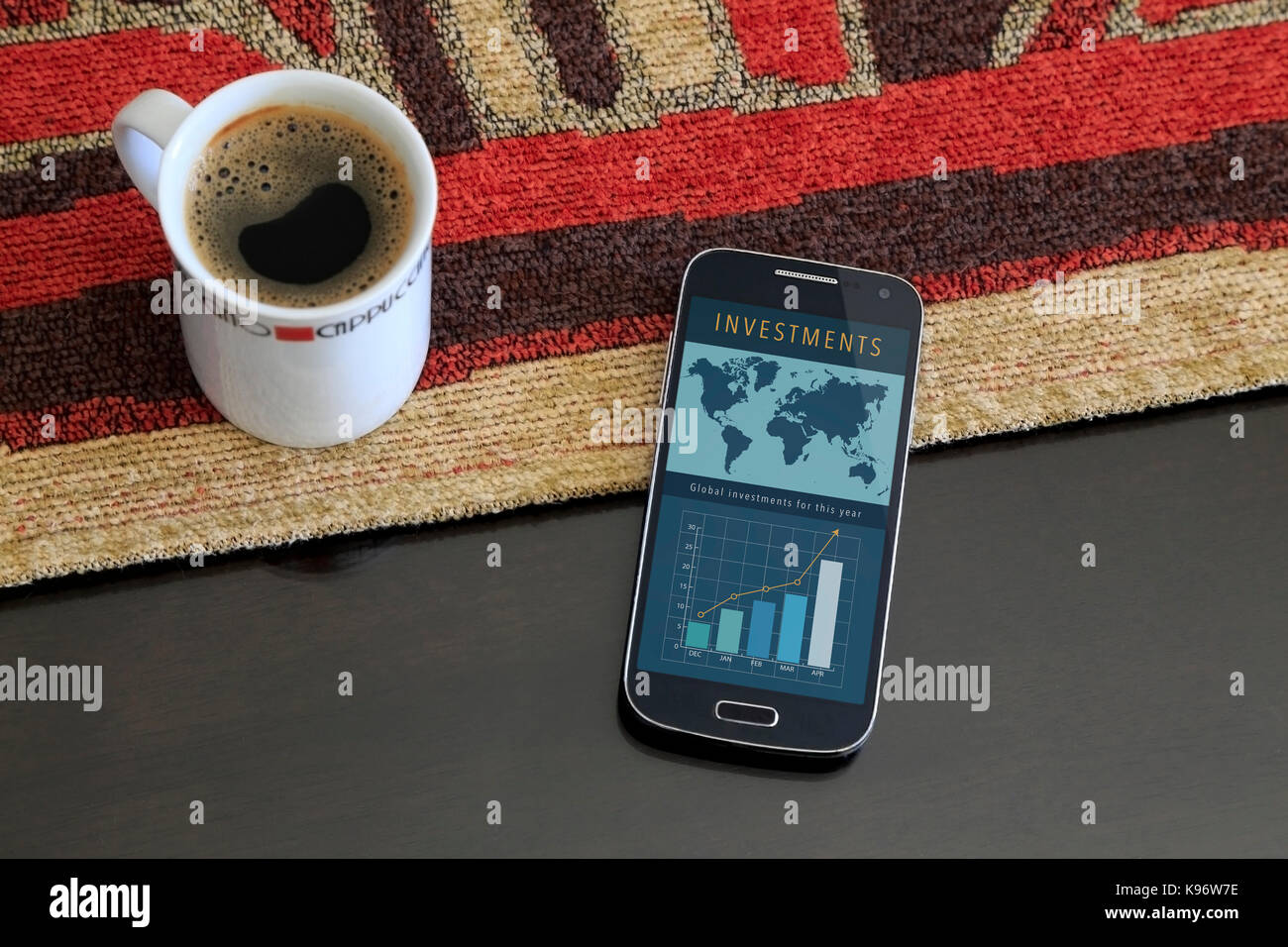 Smartphone with a investment web page on the screen. Beside a cup of coffee. Marketing, app, web page, app. Stock Photo