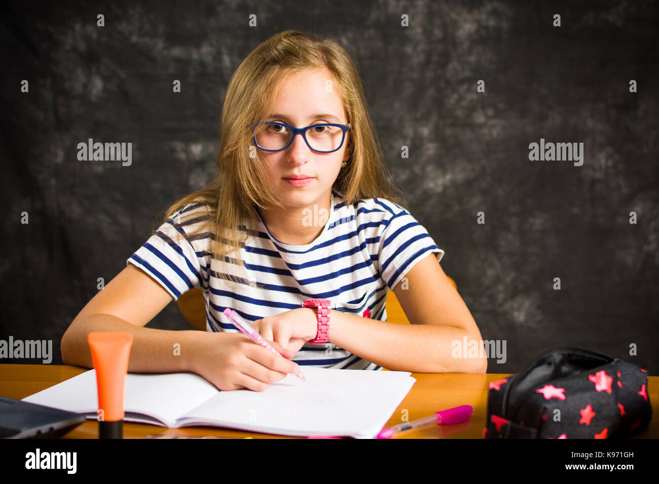 Bored teenage girl doing homework assignment at home Stock Photo