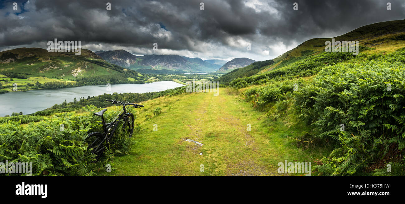 Mountain biking above Loweswater in the North-Western Lake District with heavy showers battering through the valley interspersed by short lived and ra Stock Photo