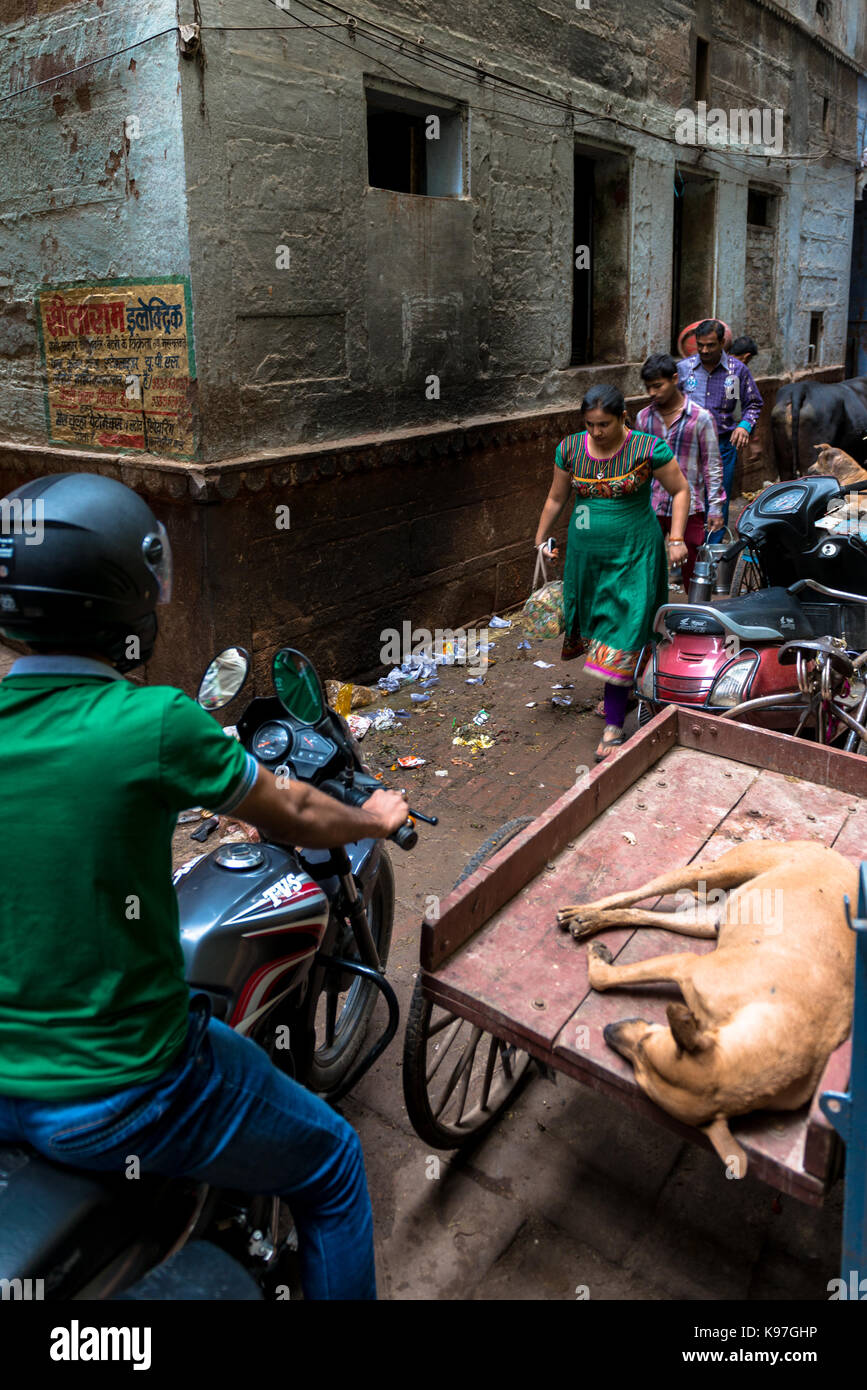 VARANASI, INDIA - MARCH 13, 2016: Vertical picture of indian people trying to move and a motorcylce in a narrow dirty street of Varanasi in India Stock Photo