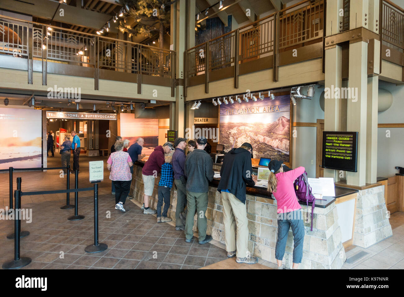 Tourists standing at the information desk inside the visitors center at