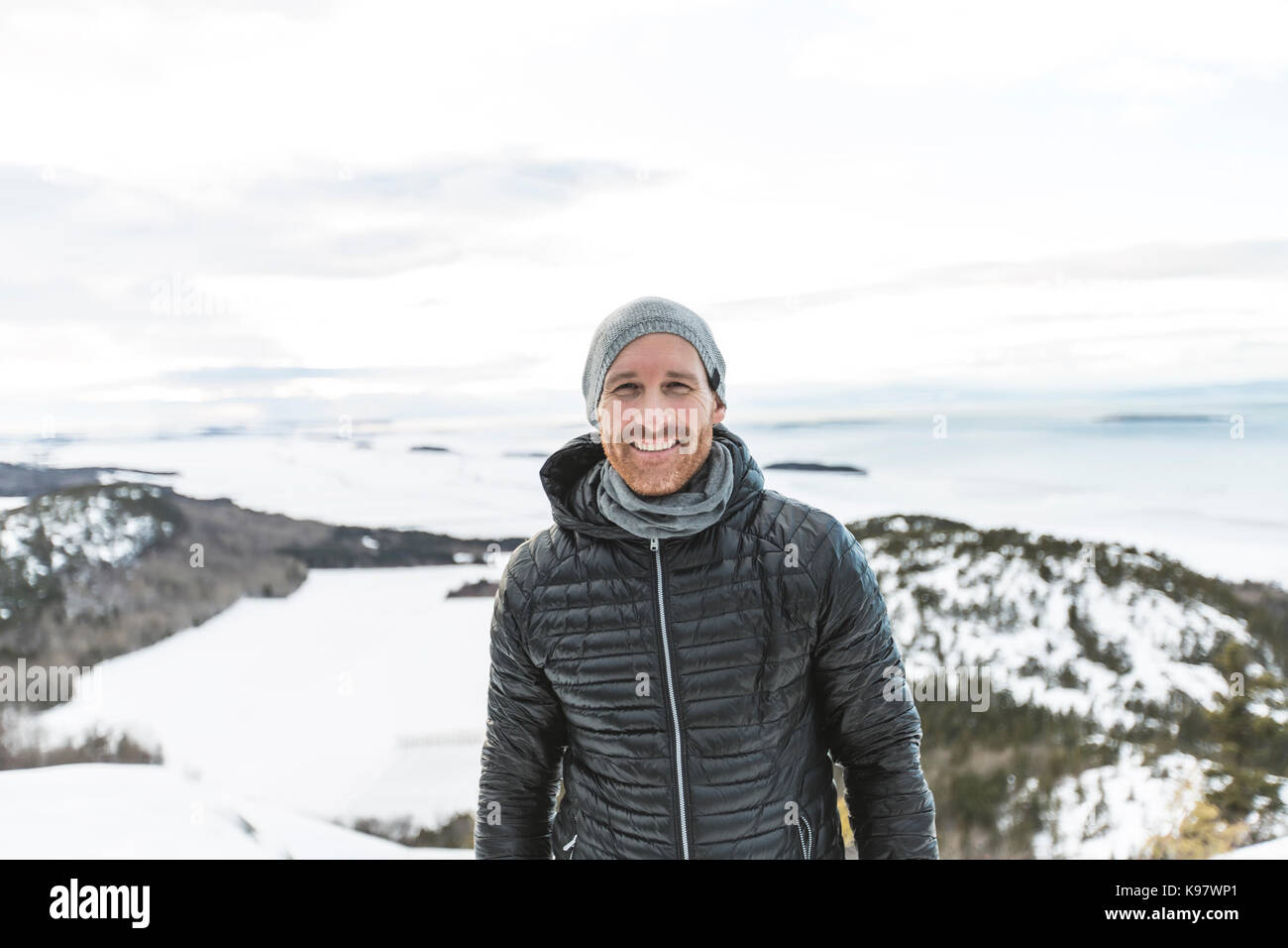 Happy young man standing outdoors on winter mountain resort Stock Photo ...
