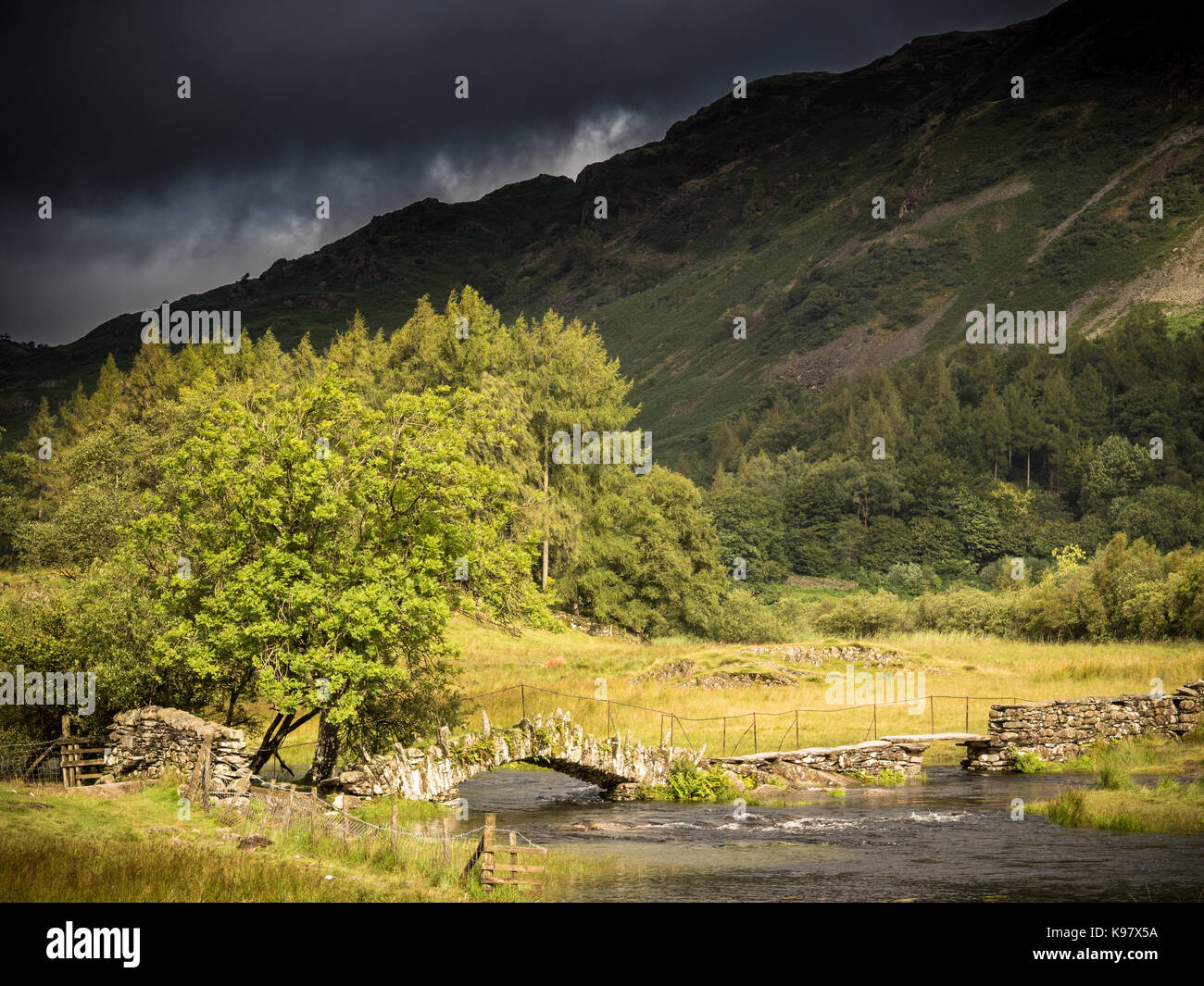 I have an uncanny ability to find myself at Slater's Bridge when dark, omminous clouds are rolling in!    Today was no exception!  Little Langdale loo Stock Photo