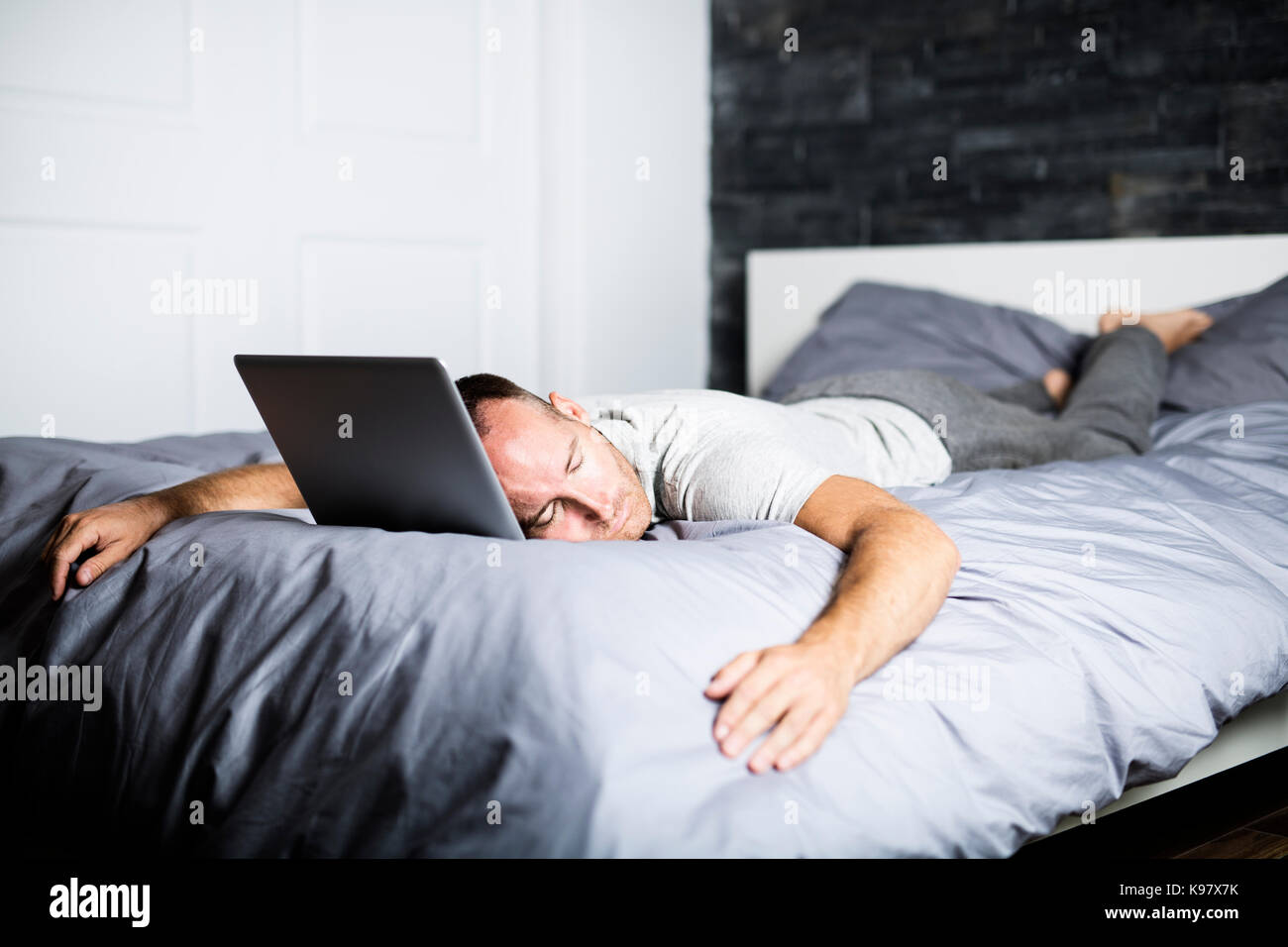 man sleeping over laptop computer in bed Stock Photo Alamy