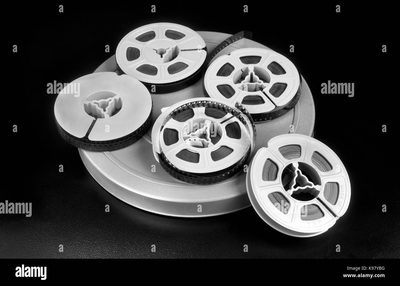 Old time 8mm film and film canisters in black and white. Stock Photo