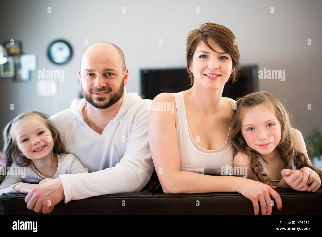 Family sitting in living room watching tv Stock Photo