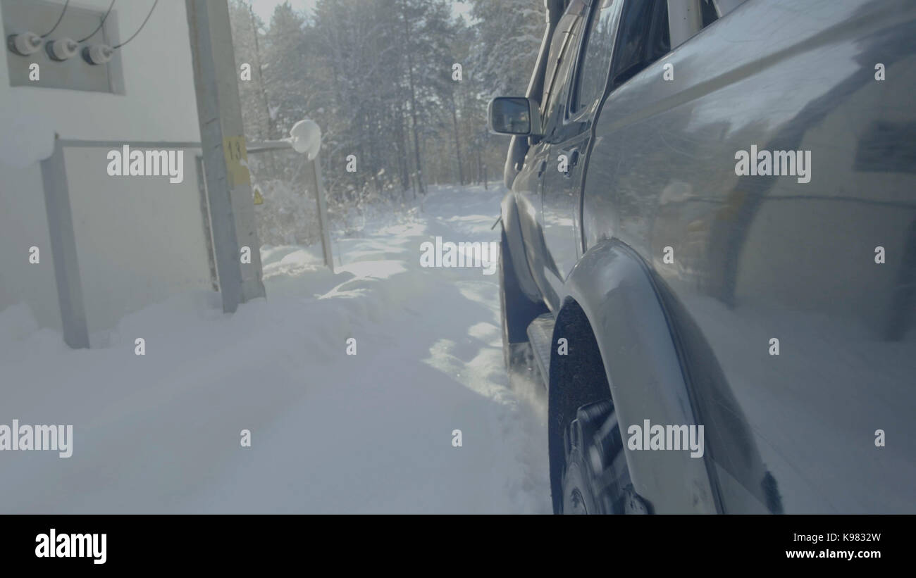 Car rides on a winter forest road. A car in a snow-covered road among ...