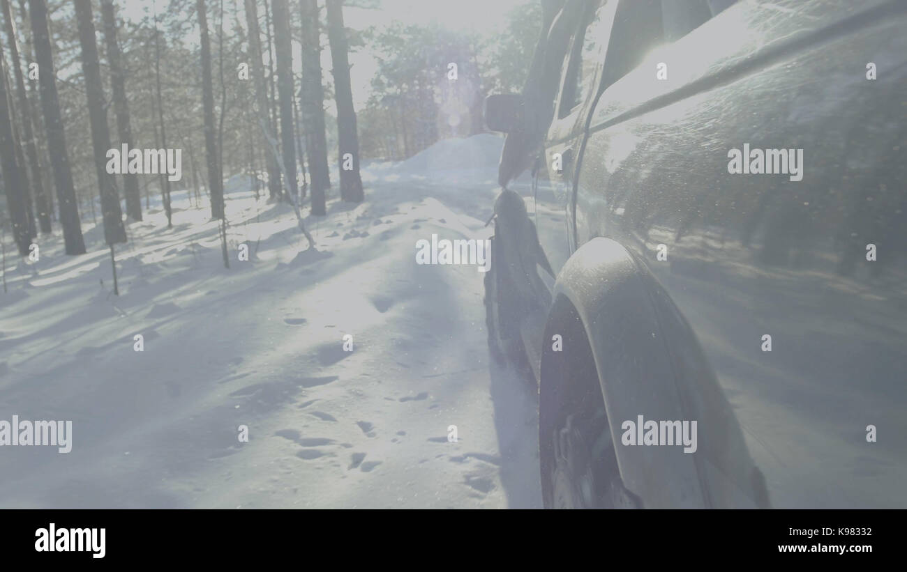 Car rides on a winter forest road. A car in a snow-covered road among ...