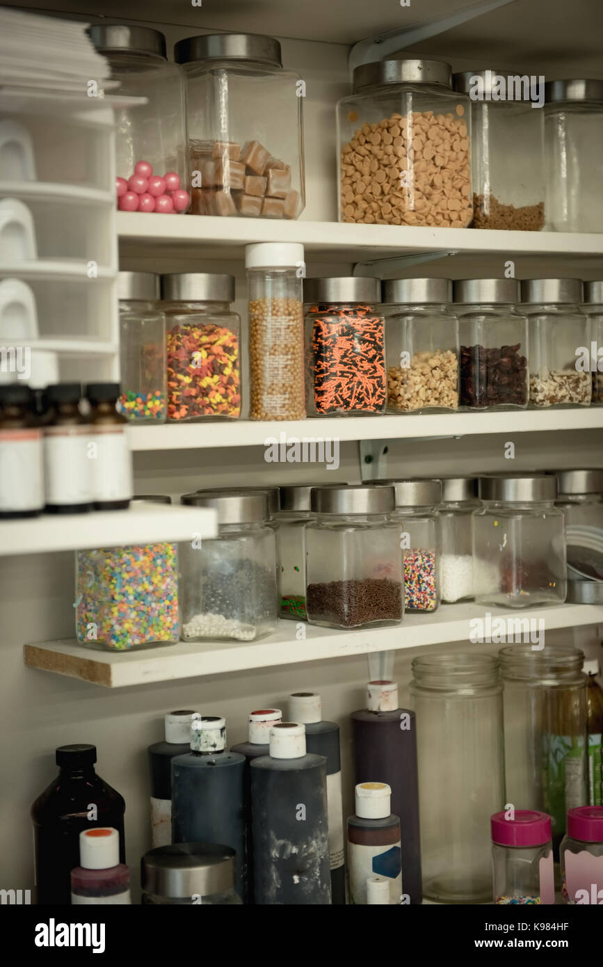 Various ingredient bottles kept in shelf at kitchen Stock Photo
