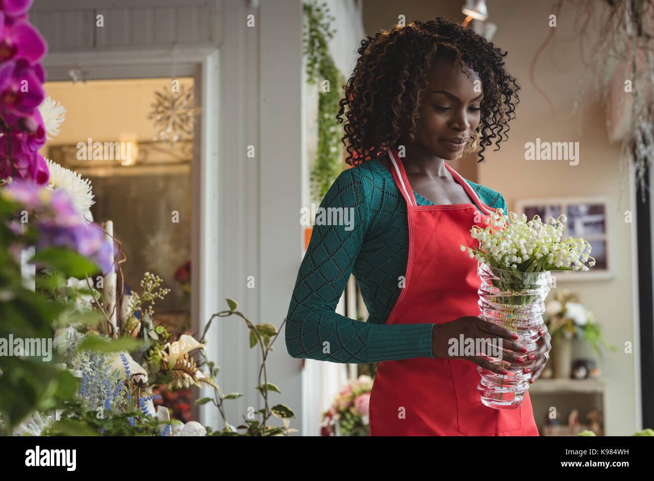 Female florist holding pot plant at his flower shop Stock Photo - Alamy