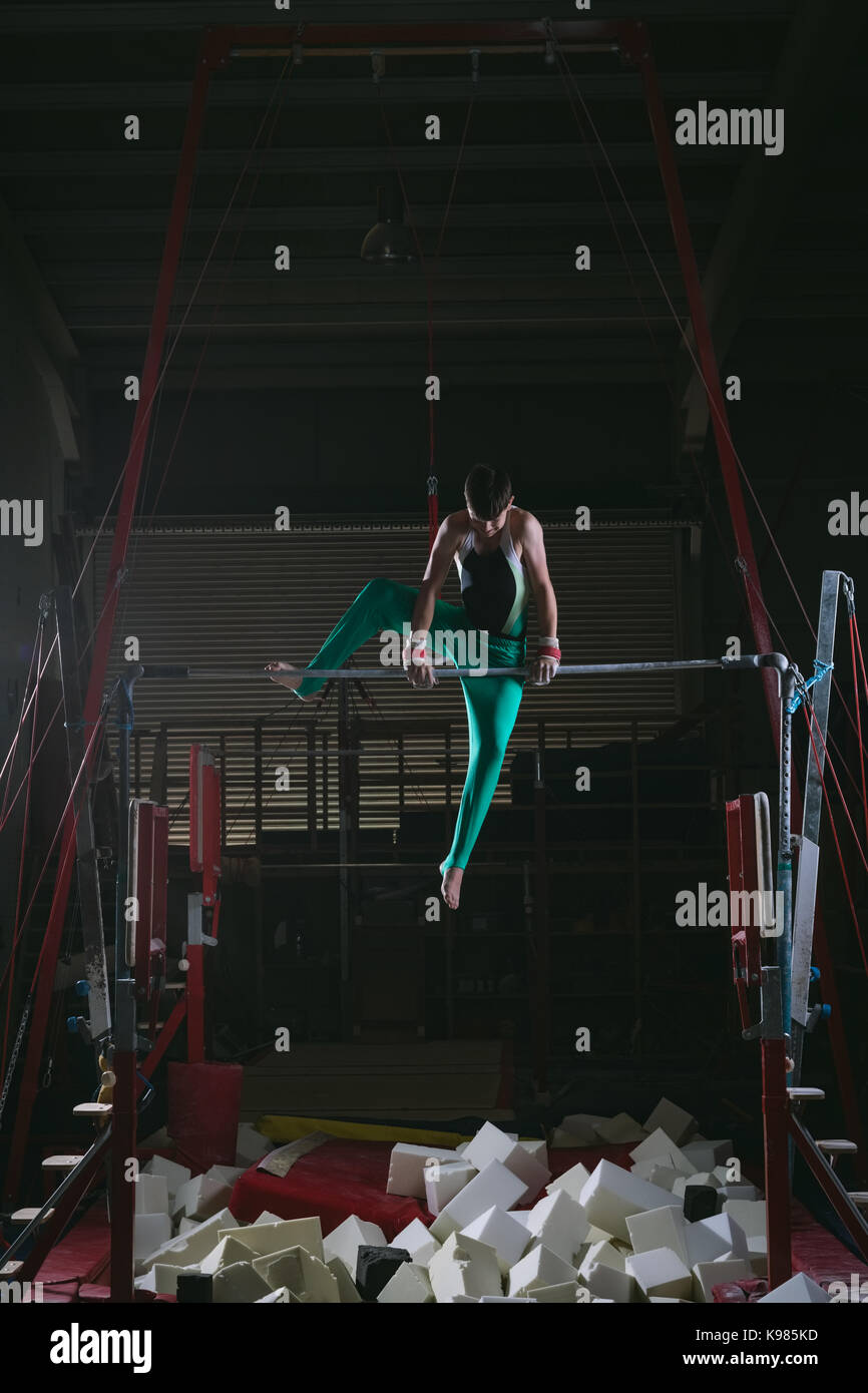 Male gymnast practicing gymnastics on the horizontal bar in the gym Stock Photo