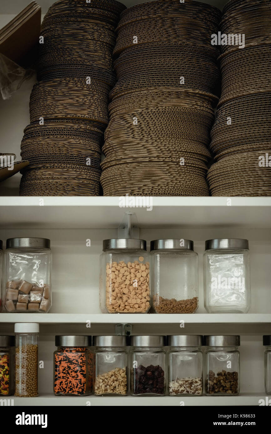 Various ingredient bottles kept in shelf at kitchen Stock Photo