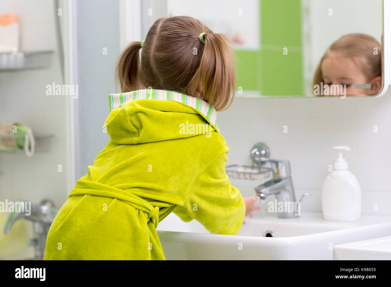 Little girl washing hands in bathroom Stock Photo