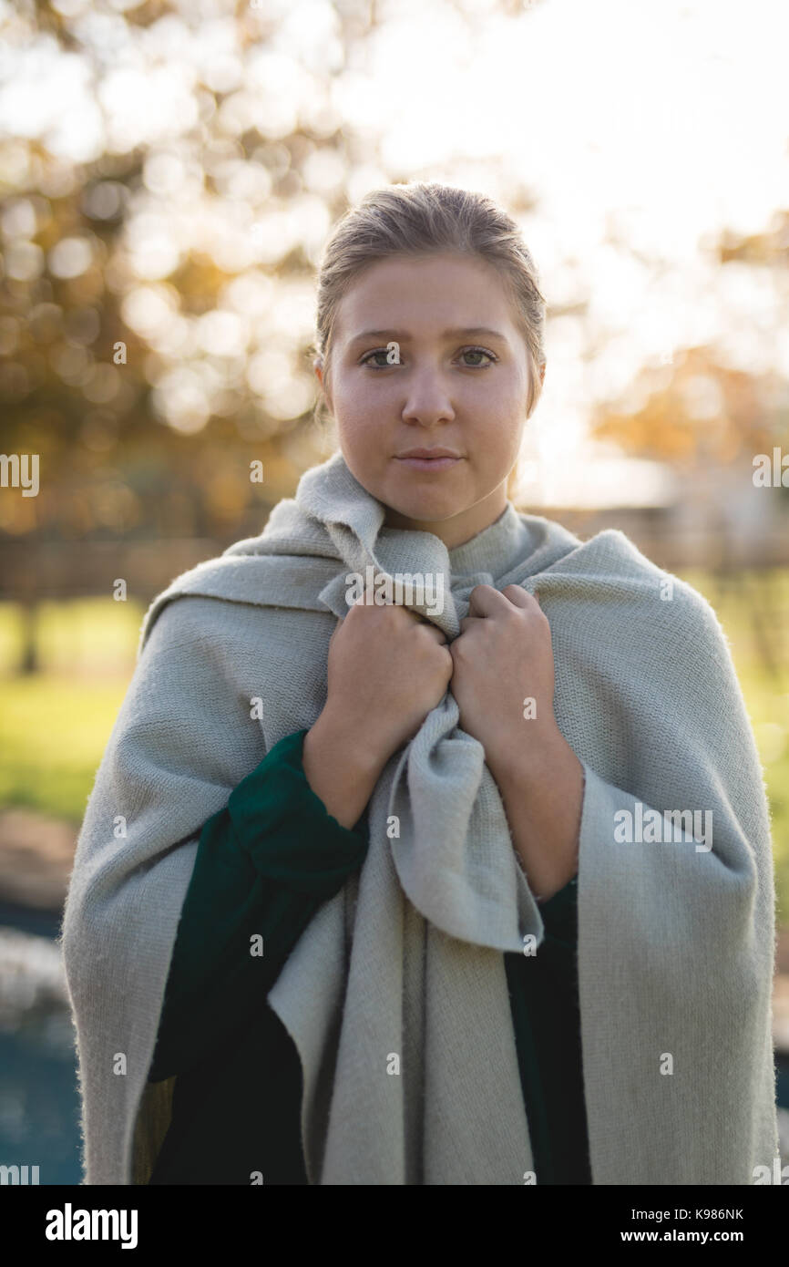 Portrait of young woman wrapped in blanket standing at park Stock Photo ...