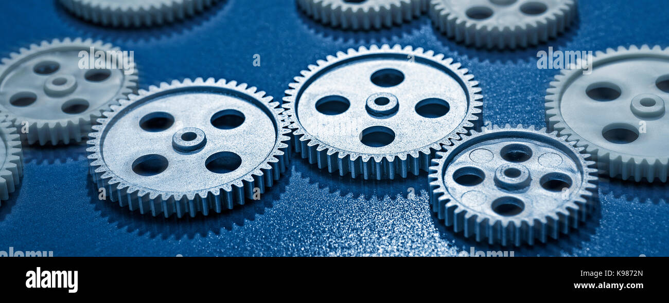 Several Gear wheels in a row on blue background Stock Photo