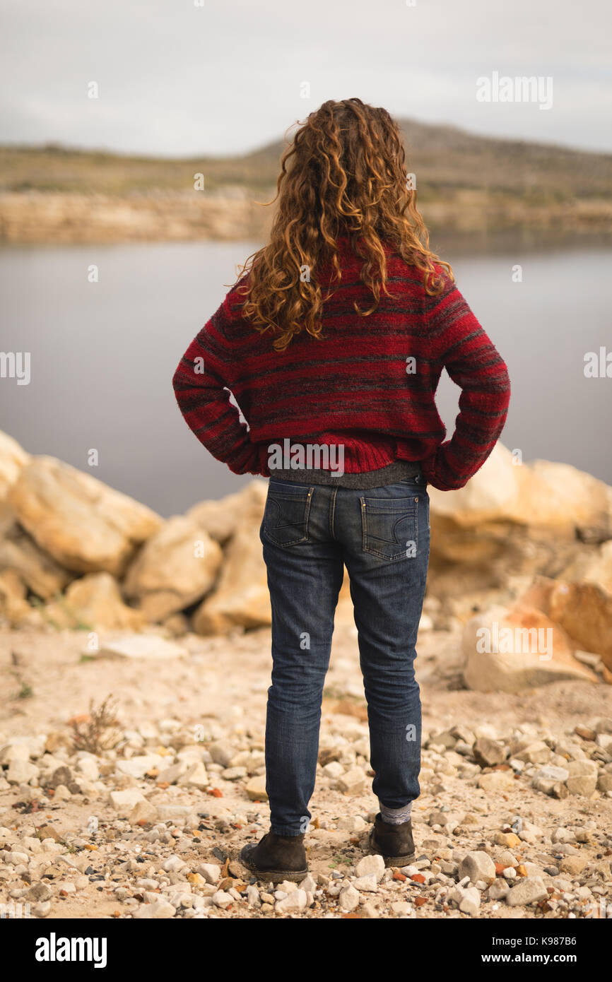 Rear view of woman standing near lakeside Stock Photo - Alamy