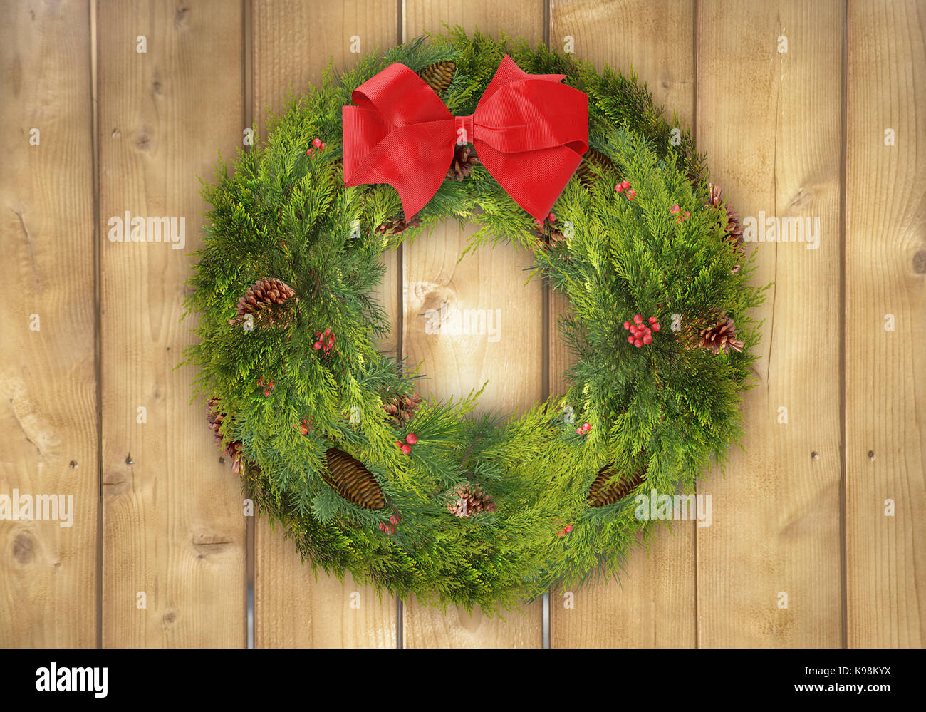 Rustic Christmas background of a pine wreath with holly berries and a ...