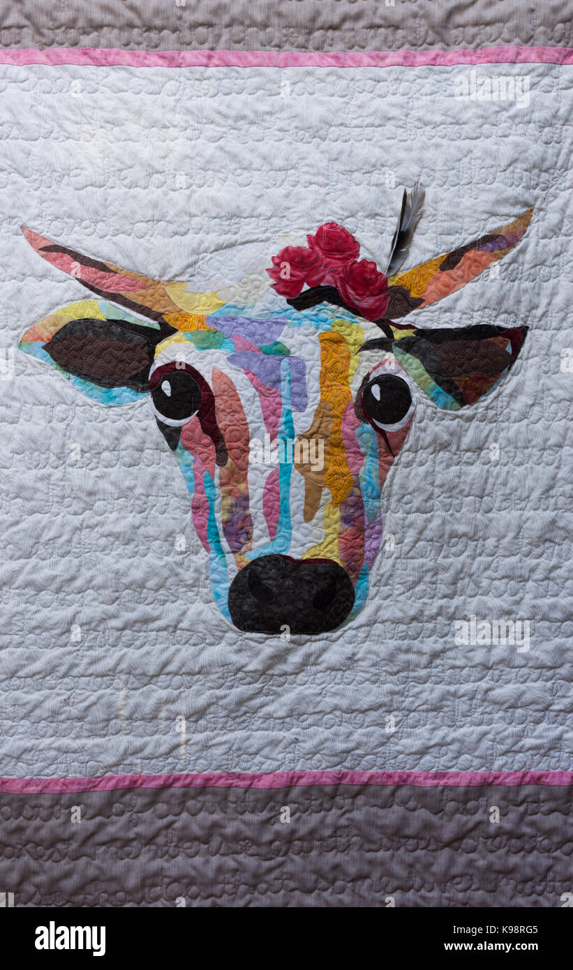 Handmade quilt featuring an abstract head of cow with horns and flowers