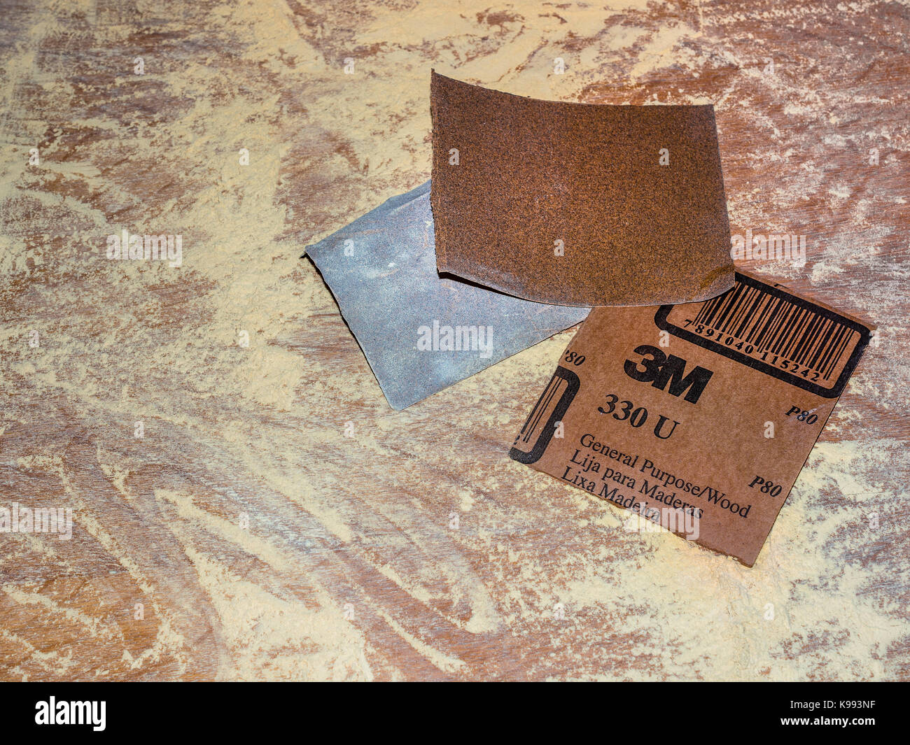 Sandpaper and sawdust on table top. Stock Photo