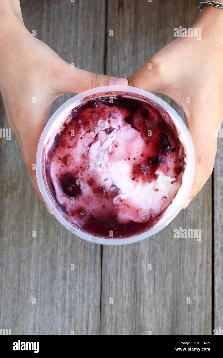Berry flavoured yogurt against wooden background Stock Photo