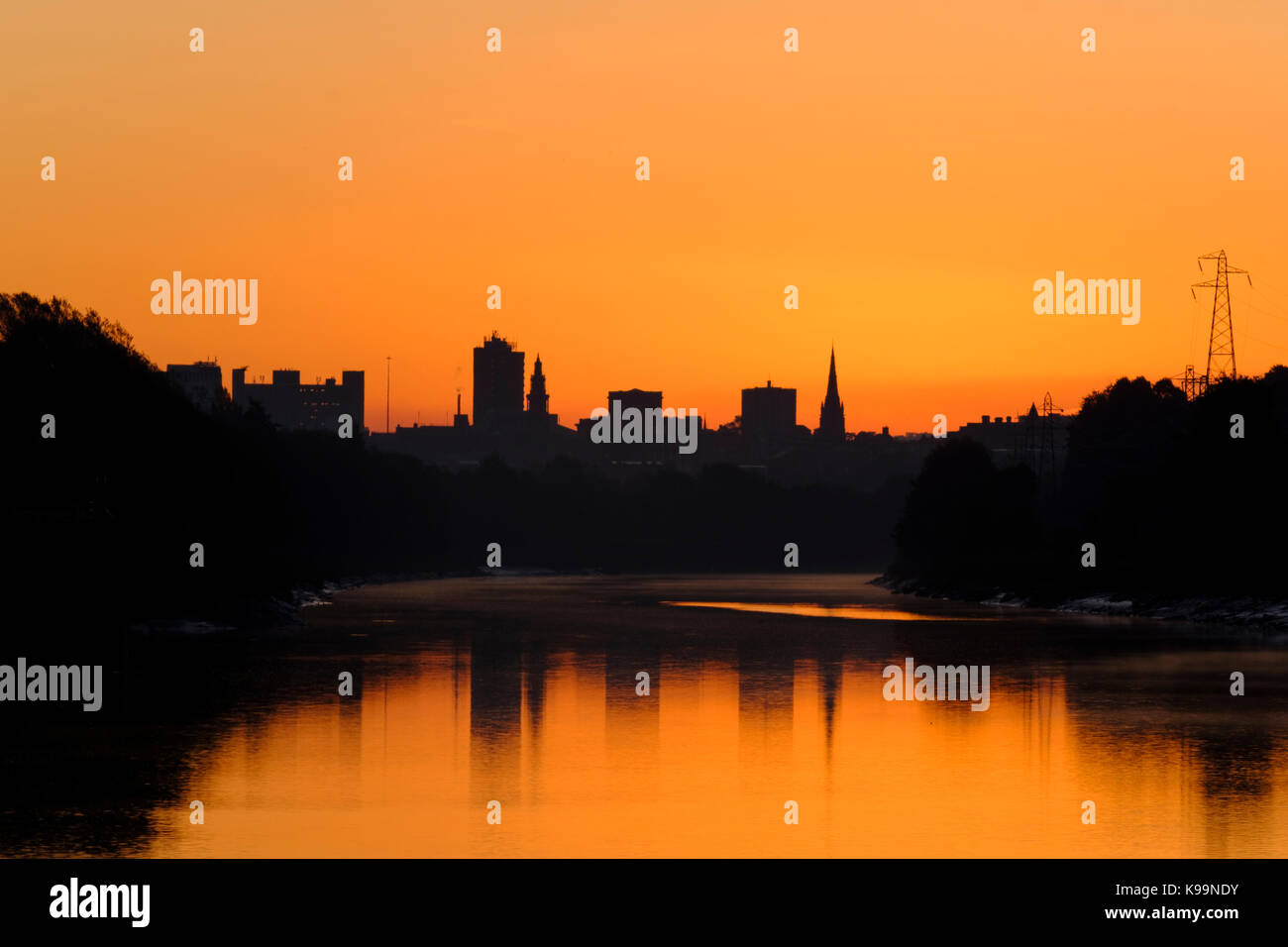 Preston, UK. 22nd Sep, 2017. The sky glowed orange at dawn broke over the River Ribble in Preston today. The city centre silhouetted against the rising sun. Credit: Paul Melling/Alamy Live News Stock Photo