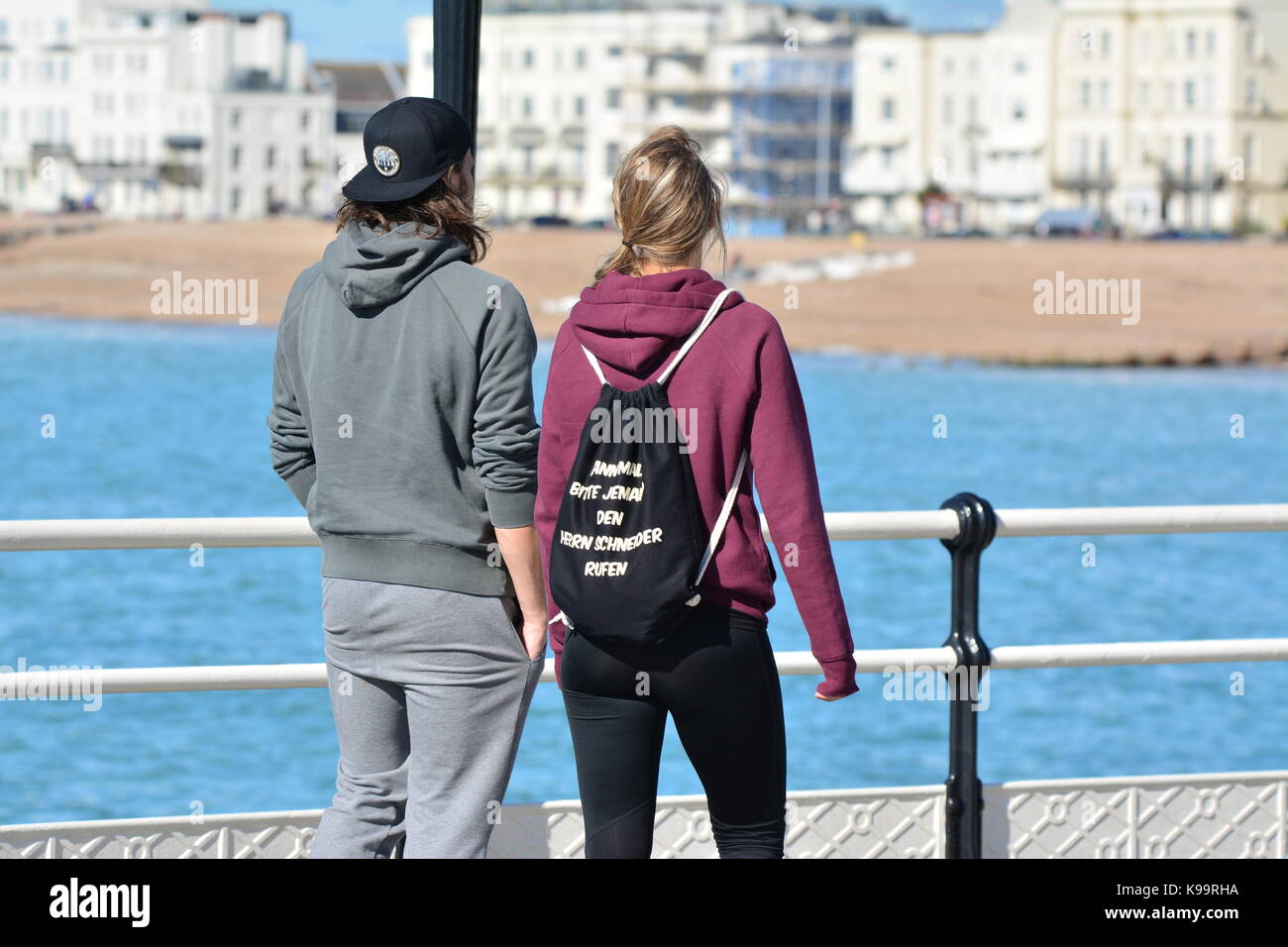 Worthing, West Sussex, England, UK. Friday 22nd September 2017. Young couple enjoying the sunshine on Worthing Pier this morning, as the weather is calm, warm and dry on the south coast of England. Credit: Geoff Smith/Alamy Live News Stock Photo