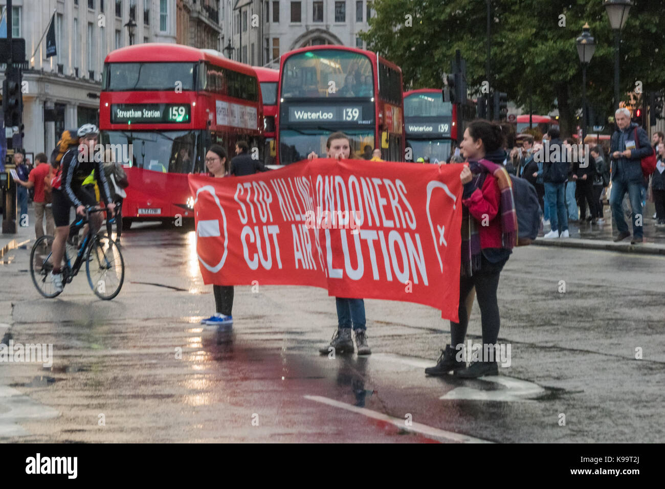 September 21, 2017 - London, UK - London, UK. 21st September 2017. Campaigners for 'Stop Killing Londoners' hold a banner in Trafalgar Square cleared of traffic - except for cyclists -  in a short protest against the illegal levels of air pollution in the capital which result in 9,500 premature deaths and much suffering from respiratory disease. In a carefully planned protest they blocked all five entrances to the roundabout at the square, emptying it of traffic while they spoke about the problem and handed out leaflets. This was the 5th protest by campaigners from Rising Up aimed at mobilisin Stock Photo