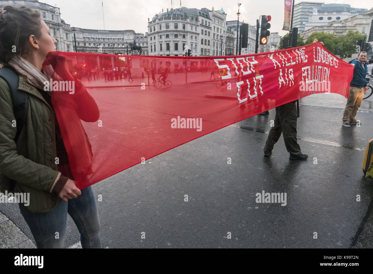 September 21, 2017 - London, UK - London, UK. 21st September 2017. Campaigners for 'Stop Killing Londoners' hold a banner in Trafalgar Square cleared of traffic in a short protest against the illegal levels of air pollution in the capital which result in 9,500 premature deaths and much suffering from respiratory disease. In a carefully planned protest they blocked all five entrances to the roundabout at the square, emptying it of traffic while they spoke about the problem and handed out leaflets. This was the 5th protest by campaigners from Rising Up aimed at mobilising people across London to Stock Photo