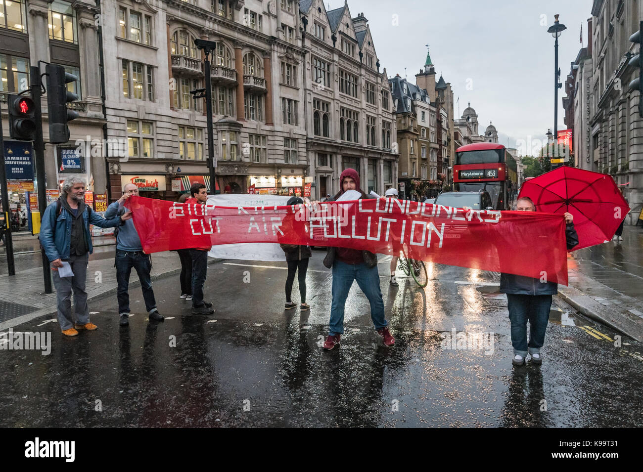 September 21, 2017 - London, UK - London, UK. 21st September 2017. Campaigners for 'Stop Killing Londoners' hold a banner across Whitehall to clear Trafalgar Square of traffic in a short protest against the illegal levels of air pollution in the capital which result in 9,500 premature deaths and much suffering from respiratory disease. In a carefully planned protest they blocked all five entrances to the roundabout at the square, emptying it of traffic while they spoke about the problem and handed out leaflets. This was the 5th protest by campaigners from Rising Up aimed at mobilising people a Stock Photo