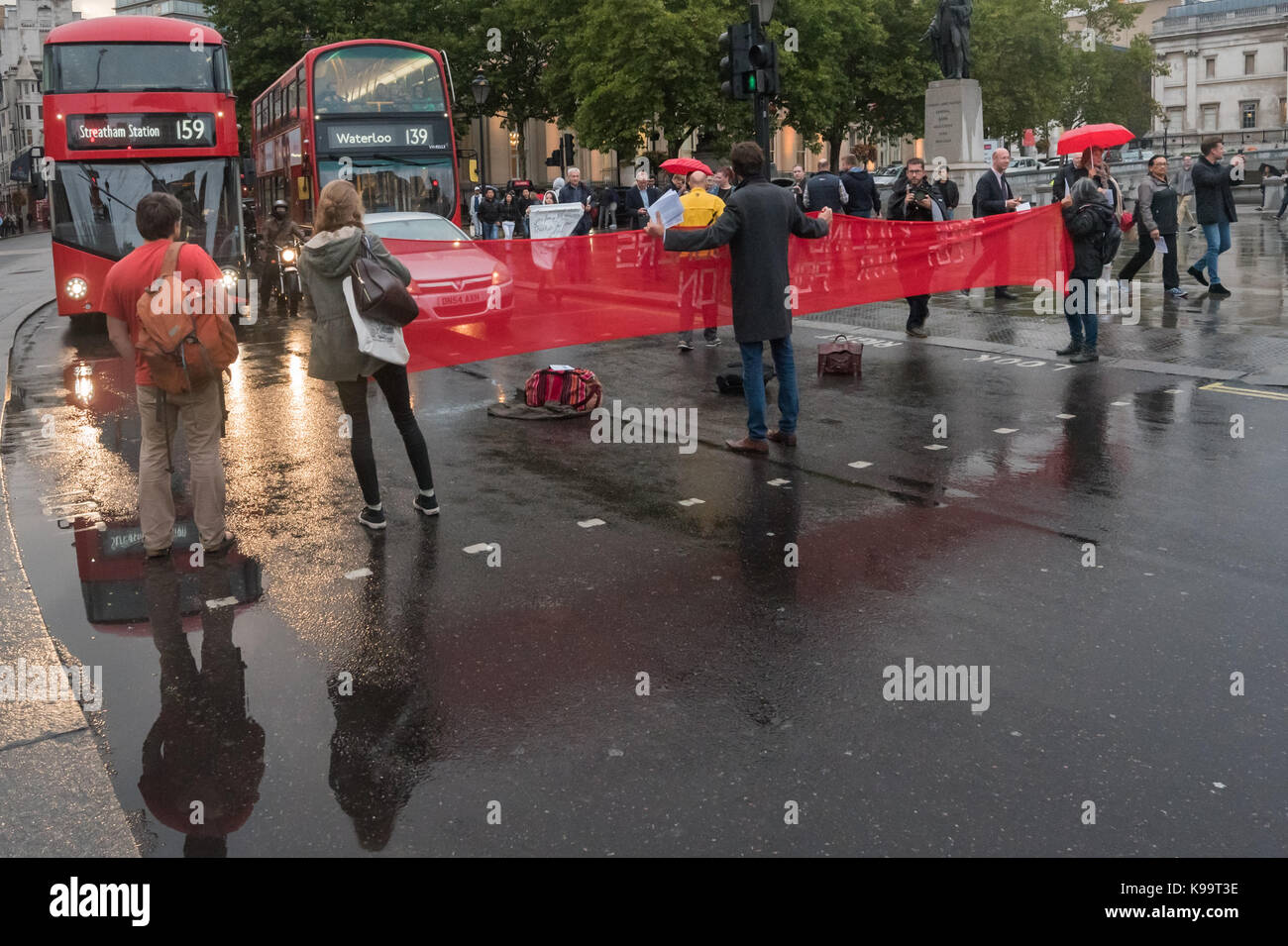 September 21, 2017 - London, UK - London, UK. 21st September 2017. Campaigners for 'Stop Killing Londoners' hold a banner across Pall Mall to clear Trafalgar Square of traffic in a short protest against the illegal levels of air pollution in the capital which result in 9,500 premature deaths and much suffering from respiratory disease. In a carefully planned protest they blocked all five entrances to the roundabout at the square, emptying it of traffic while they spoke about the problem and handed out leaflets. This was the 5th protest by campaigners from Rising Up aimed at mobilising people a Stock Photo