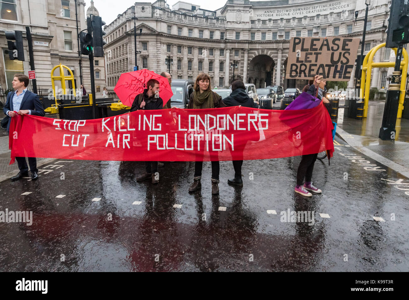 September 21, 2017 - London, UK - London, UK. 21st September 2017. Campaigners for 'Stop Killing Londoners' hold a banner across the Mall to clear Trafalgar Square of traffic in a short protest against the illegal levels of air pollution in the capital which result in 9,500 premature deaths and much suffering from respiratory disease. In a carefully planned protest they blocked all five entrances to the roundabout at the square, emptying it of traffic while they spoke about the problem and handed out leaflets. This was the 5th protest by campaigners from Rising Up aimed at mobilising people ac Stock Photo