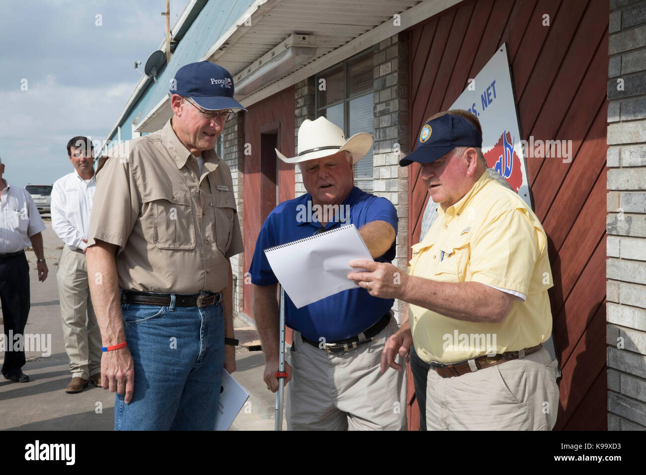 El Campo, USA. 21st Sep, 2017. U.S. Secretary of Agriculture Sonny Perdue (yellow shirt), House Agriculture Chairman Mike Conaway (tan) and Texas Agriculture Commissioner Sid Miller (blue) tour cotton farms ravaged by Hurricane Harvey three weeks ago. Credit: Bob Daemmrich/Alamy Live News Stock Photo