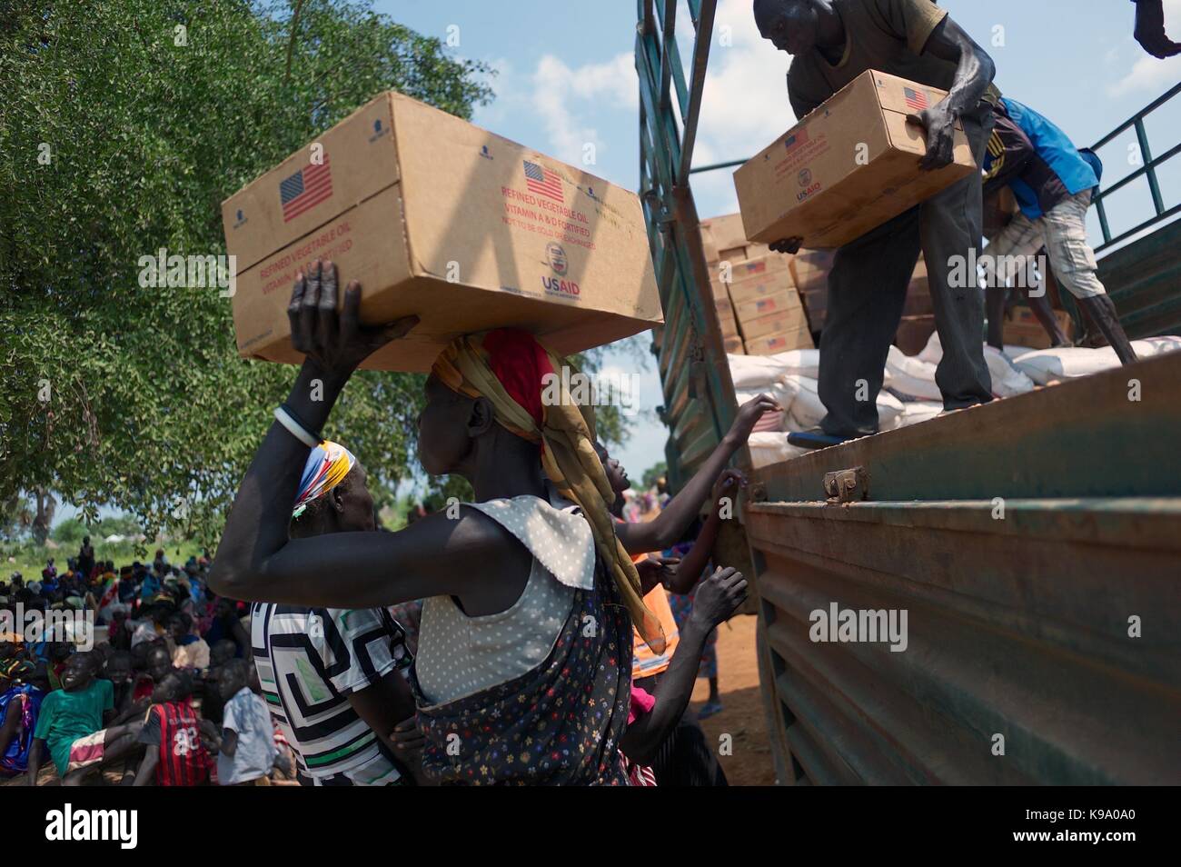 August 28, 2014 - Panweel Village - Kolnyang Payam, Bor County, South Sudan - Internally displaced refugees unload refined vegetable oil from a truck. Thousands of South Sudanese became internally displaced refugees in Jonglei and Juba following the outbreak of fighting between forces loyal to South Sudan president Salvar Kiir and his ex-vice president Rick Machar in December 2013. To help displaced and conflict-affected households return home and start the recovery process aid organizations have engaged in emergency response activities such as providing emergency food rations. (Credit Image:  Stock Photo