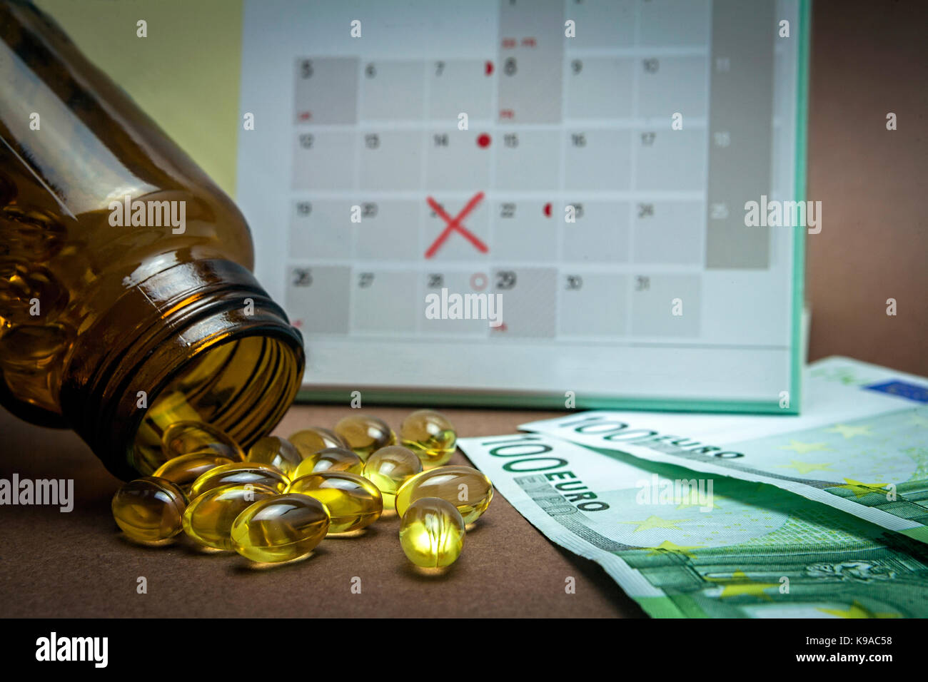 Calendar noting the day of payment, bottle with pills of garlic oil along with two tickets of one hundred euros, concept of pharmaceutical copayment Stock Photo