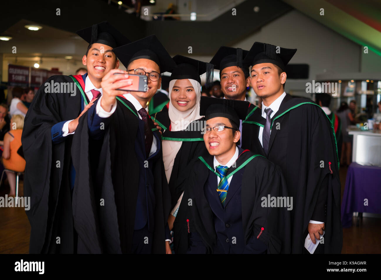 Higher Education in the UK: A group of foreign overseas Asian Aberystwyth University students wearing traditional academic gowns and mortar boards taking a selfie photograph  on their graduation day, July 2017 Stock Photo