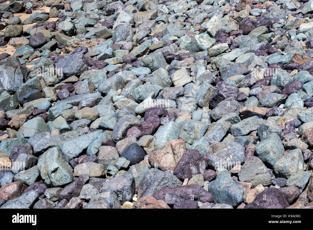 Pebbles on the beach in lovely shades of blue, grey and purple. Stock Photo