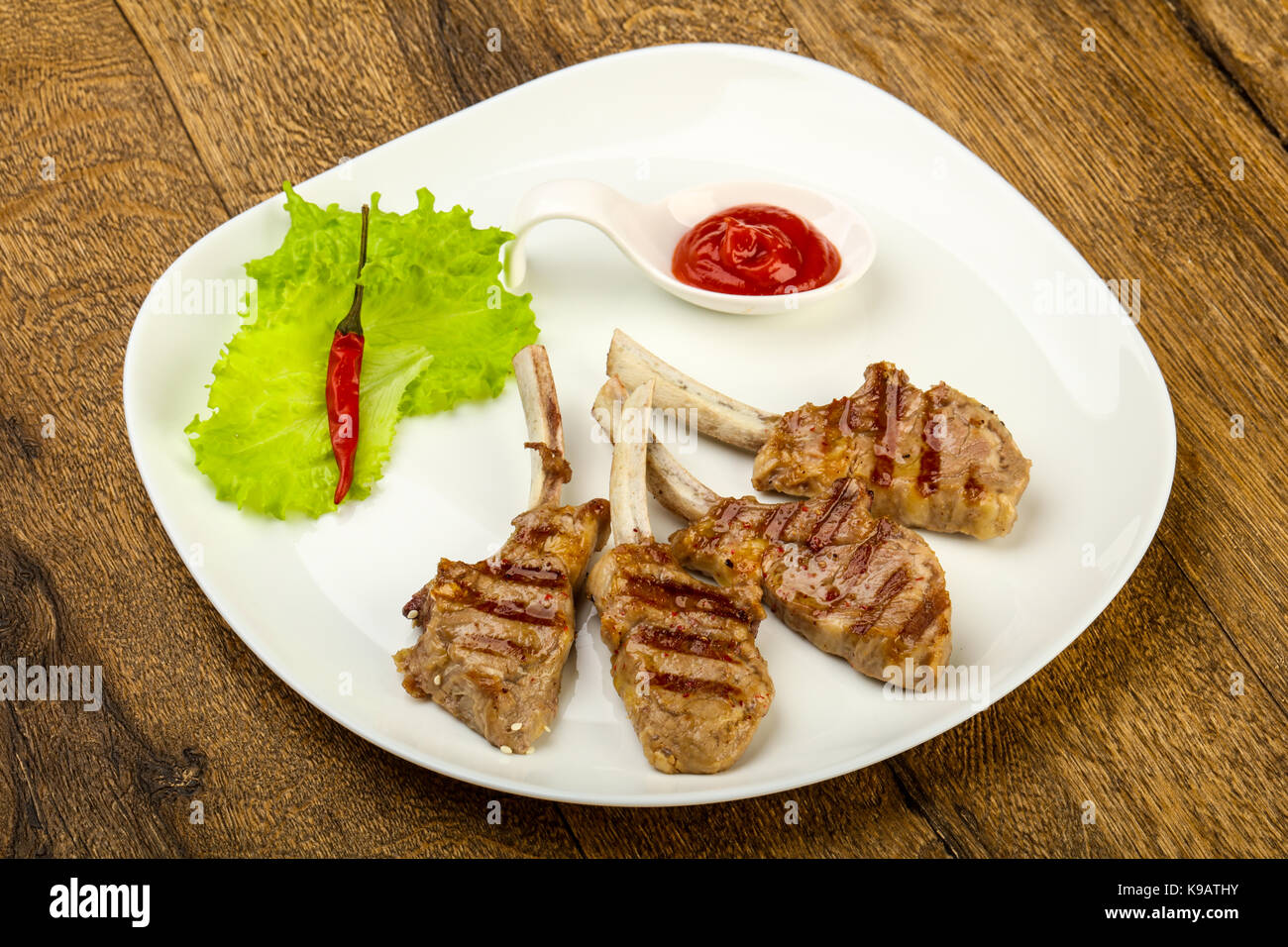 Grilled lamb with tomato sauce served salad leaves Stock Photo Alamy