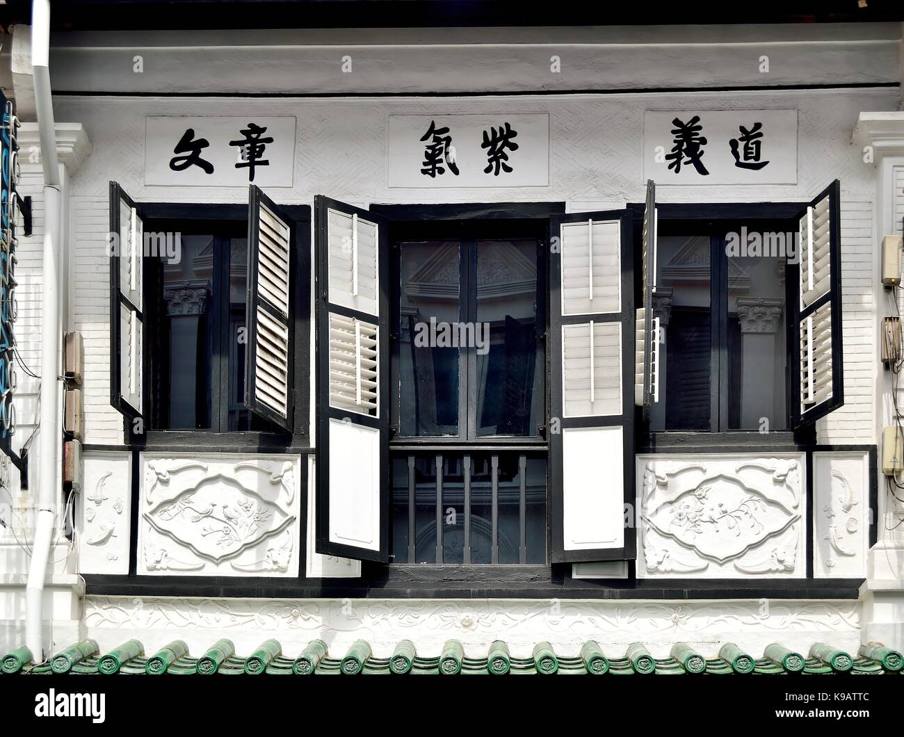 Traditional Singapore shop house exterior with windows and black and white wooden louvered shutters and Chinese calligraphy on historic Duxton Road Stock Photo