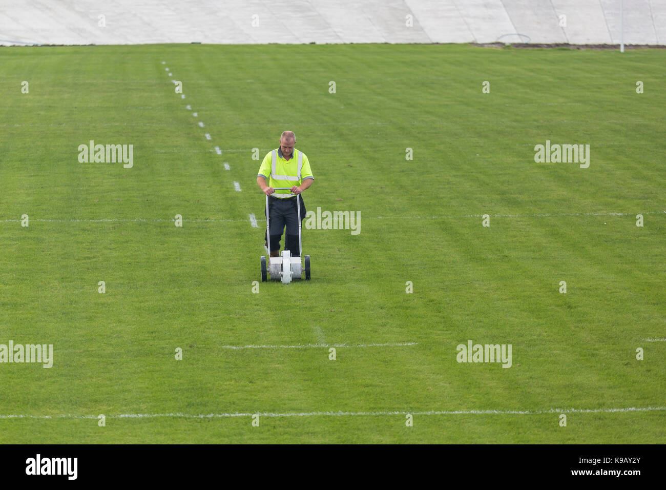 Groundsman marks out rugby pitch lines on field Stock Photo