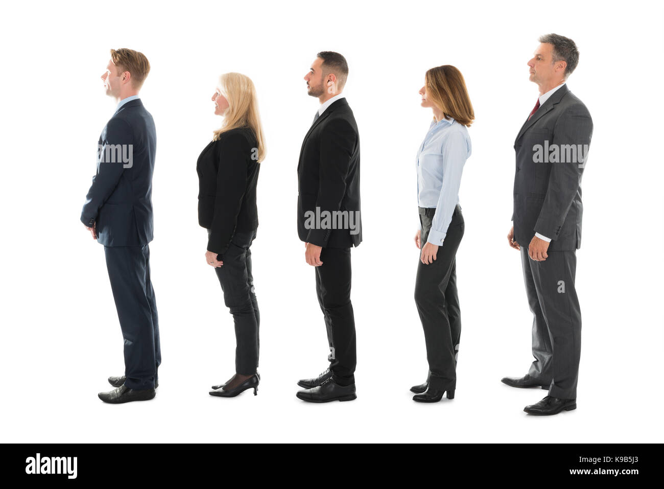 Full length side view of business people standing in row over white background Stock Photo