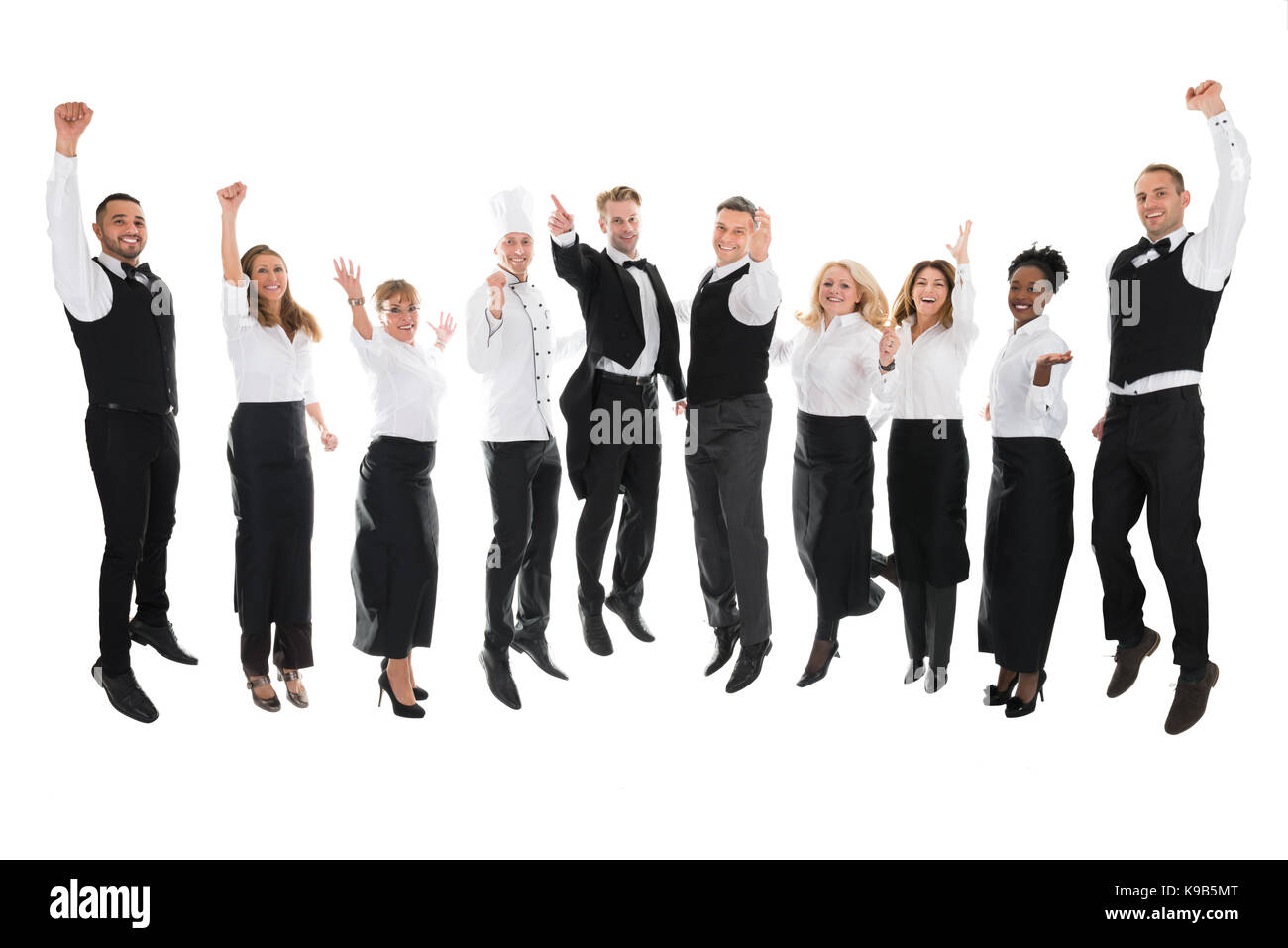 Full length portrait of happy restaurant staff celebrating success against white background Stock Photo