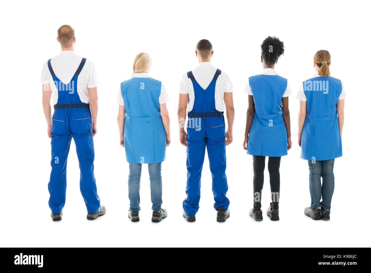 Full length rear view of multiethnic janitors standing in row against white background Stock Photo