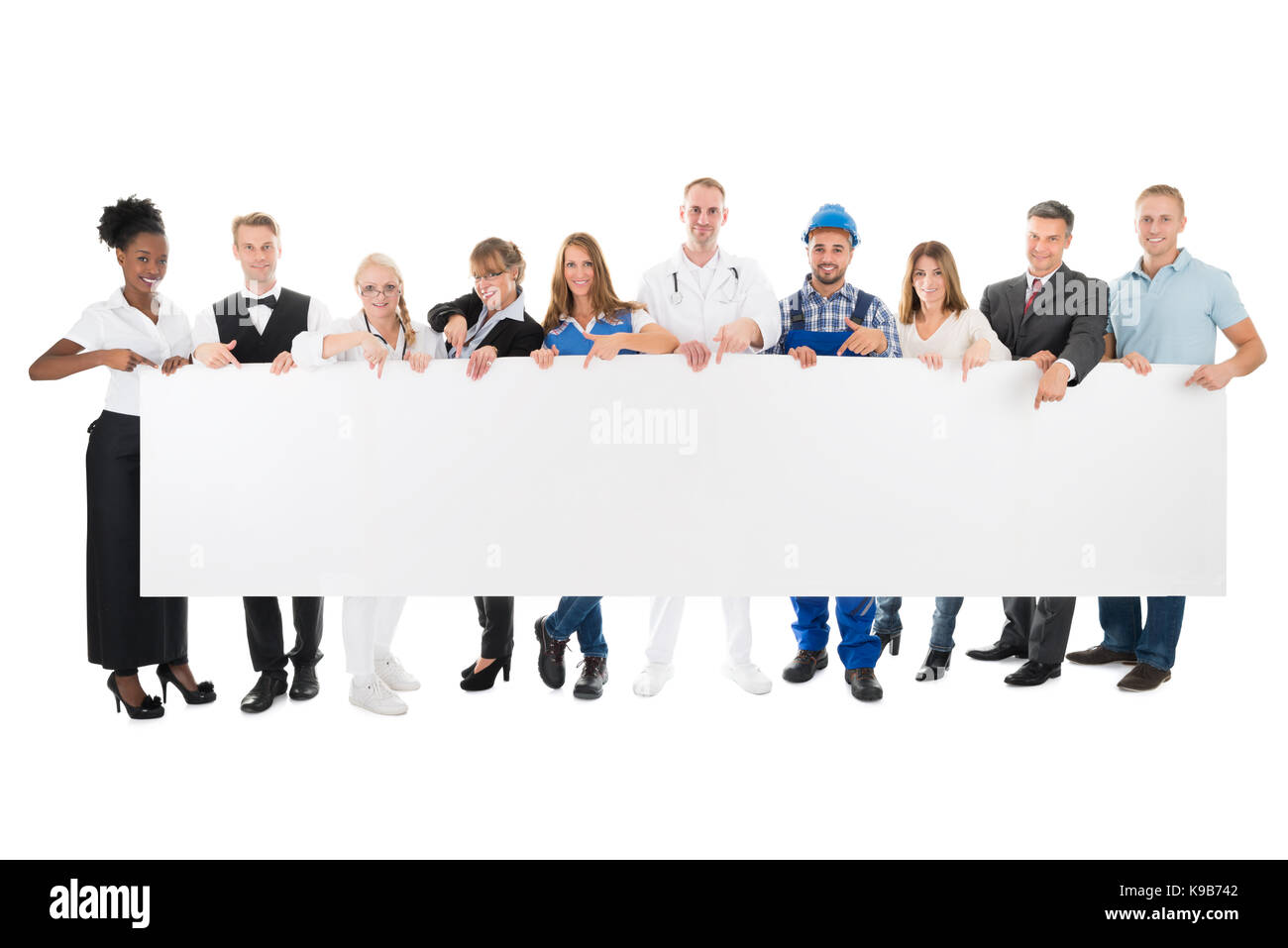 Group portrait of people with various occupations holding blank billboard against white background Stock Photo