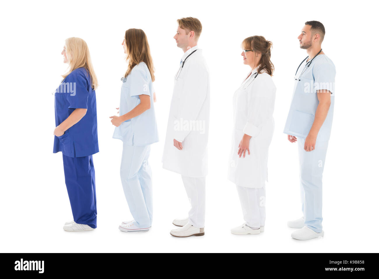 Full length side view of medical professionals standing in row against white background Stock Photo