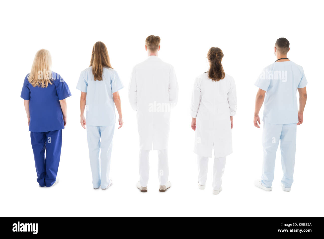 Full length rear view of medical professionals standing against white background Stock Photo