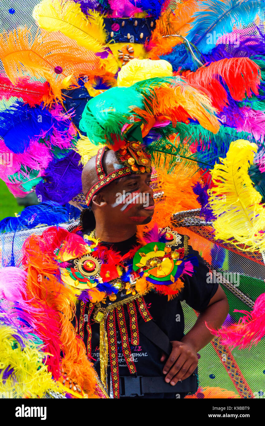 Male performer dressed in a colourful feather costume during the