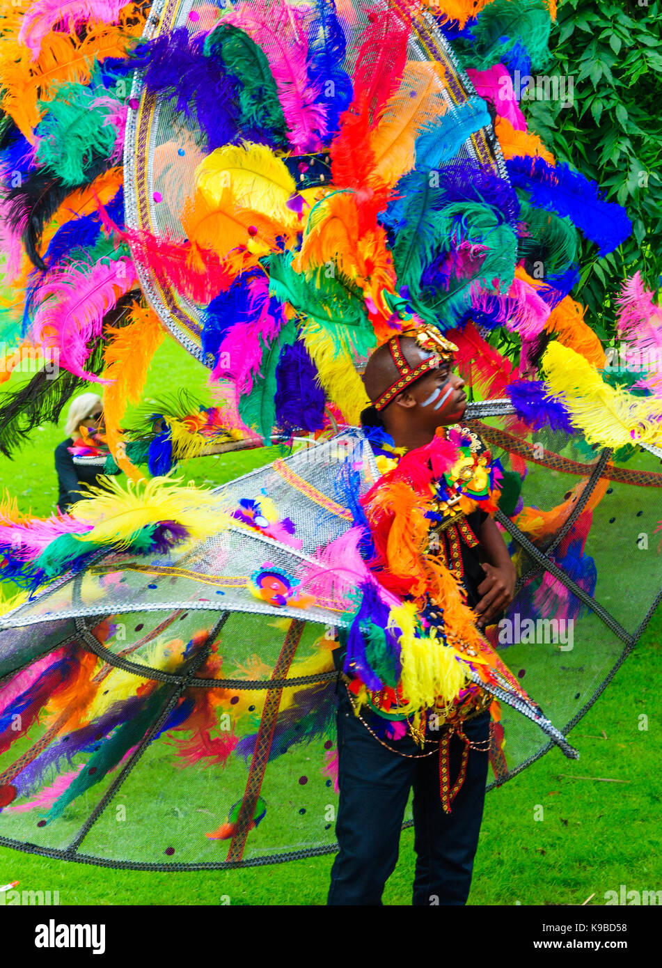 Male performer dressed in a colourful feather costume during the