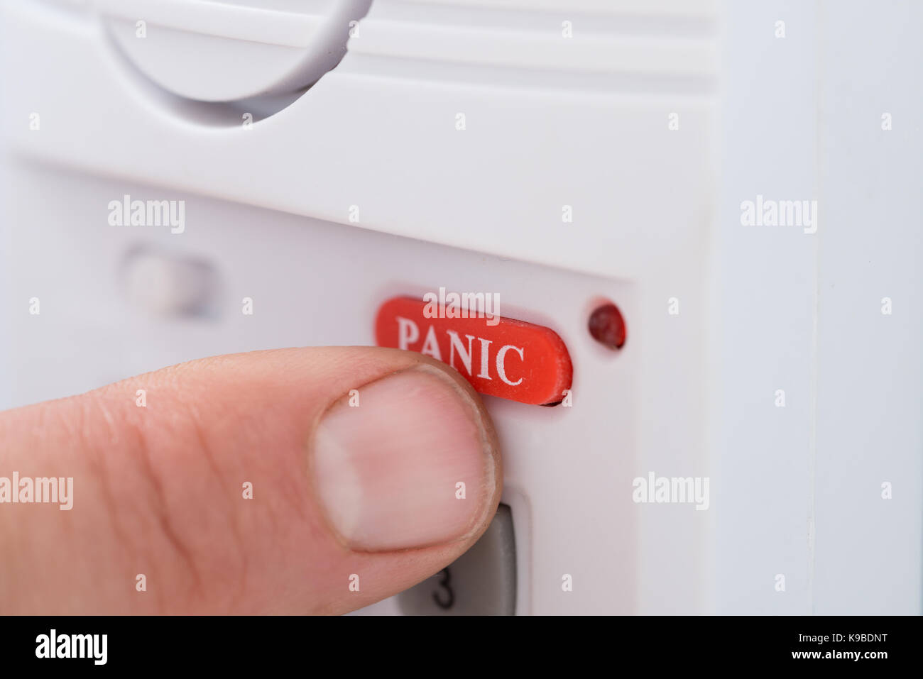Close-up Of Person's Hand Pressing Panic Button Stock Photo